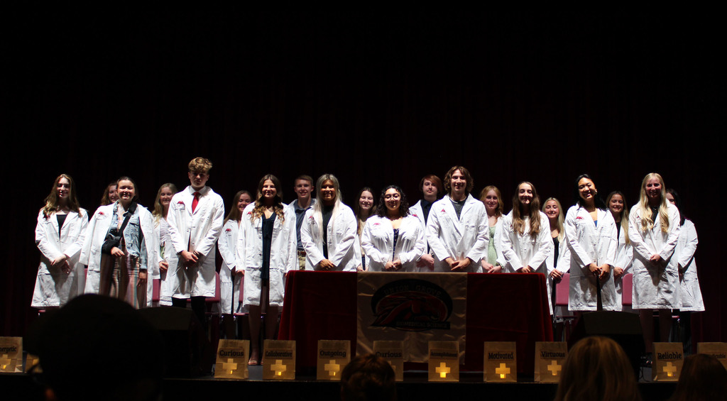 Students on stage in white lab coats